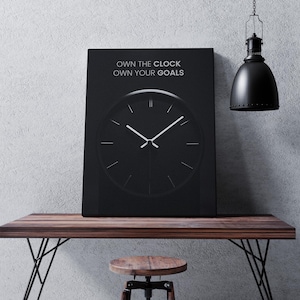 May include: Black and white motivational poster with a clock face and the text "Own the Clock Own Your Goals".