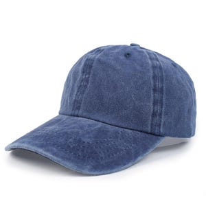 Op de afbeelding: Effen blauwe baseballpet met een gebogen klep. De pet is gemaakt van een zachte, getextureerde stof en heeft een kleine knoop aan de bovenkant. Een klassieke stijl, geschikt voor casual wear.
