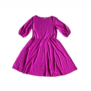 May include: A purple polka dot dress with a round neckline and 3/4 sleeves.