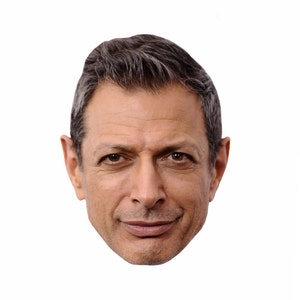 May include: A close-up portrait of a man with short, dark brown hair. He is looking directly at the camera with a slight smile. His facial features are prominent, with a defined jawline and a strong brow.