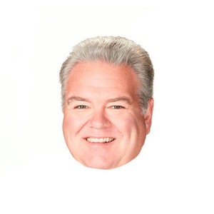 May include: A close-up portrait of a man with short, grey hair. He is smiling and has a friendly expression.