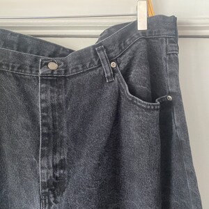 May include: A pair of dark gray denim jeans with a single front pocket and a button closure.