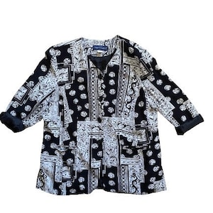 Puede incluir: Una chaqueta negra y blanca con estampado, cuello en V y mangas tres cuartos.