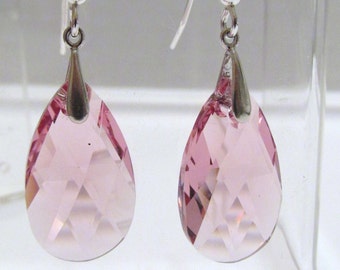 May include: A pair of silver dangle earrings with pink teardrop-shaped crystal stones.