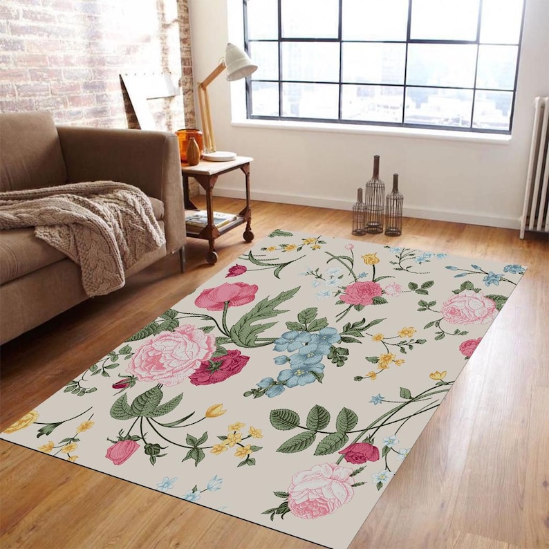 May include: A floral area rug with a cream background and pink, blue, and yellow flowers. The rug has a vintage floral pattern and is perfect for adding a touch of elegance to any room.