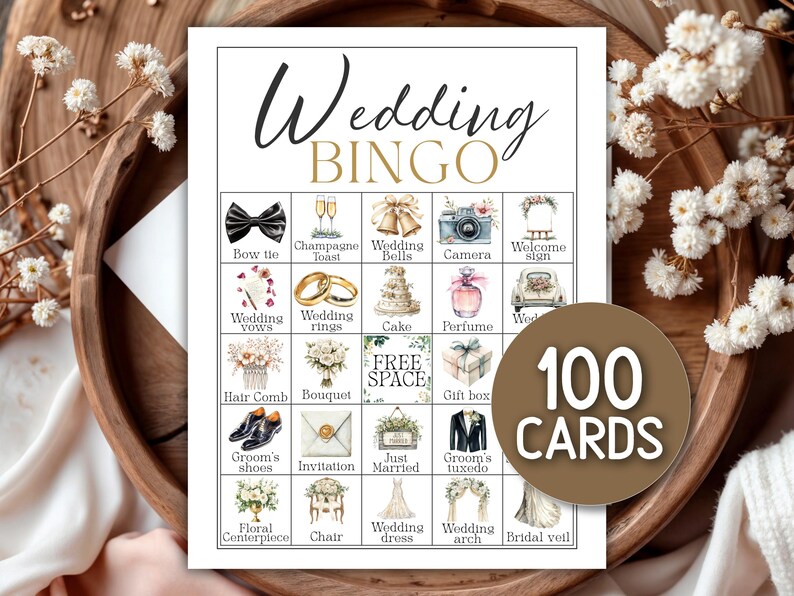 May include: A wedding bingo game card with various wedding-themed illustrations, including a bow tie, wedding rings, and a wedding cake. The card reads "Wedding BINGO" and includes a circular label that says "100 CARDS". The card is set on a wooden tray.