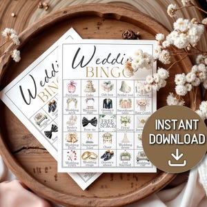 May include: Two wedding bingo cards with illustrations of wedding-related items like perfume, cake, and rings. The cards are on a wooden tray with white flowers and the words "Wedding Bingo" in elegant script. A brown circle with the words "Instant Download" is on the right.