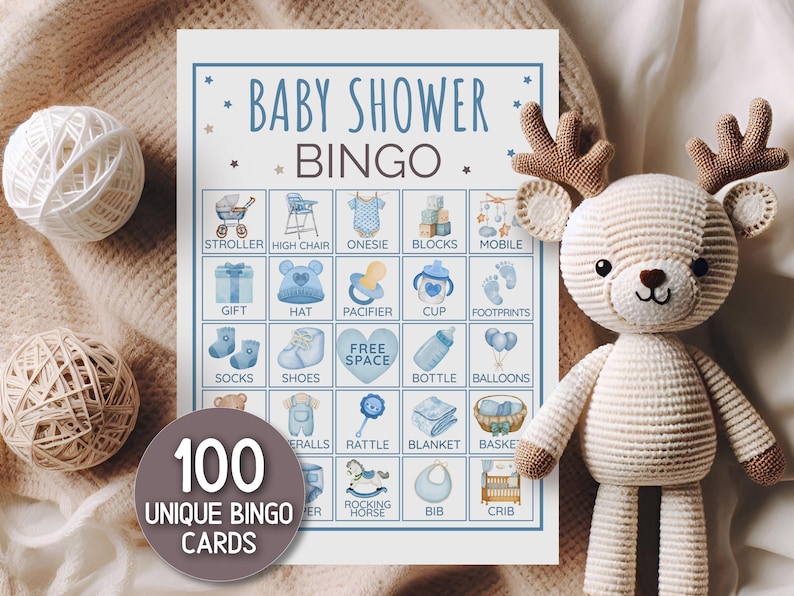 May include: Baby shower bingo card featuring blue watercolour illustrations of baby items. The card reads "Baby Shower Bingo" and "100 Unique Bingo Cards". A crocheted deer and yarn balls are in the background.