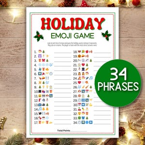 May include: A festive holiday emoji game sheet with the title "HOLIDAY EMOJI GAME" in red. The sheet features 34 phrases to guess, with a green circle that says "34 PHRASES". The game is set against a wooden background.