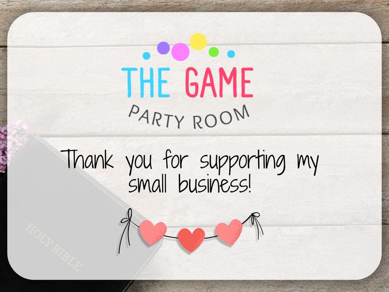 May include: A white card with the text "THE GAME PARTY ROOM" in colorful letters and a message: "Thank you for supporting my small business!" Three pink hearts hang below the message.