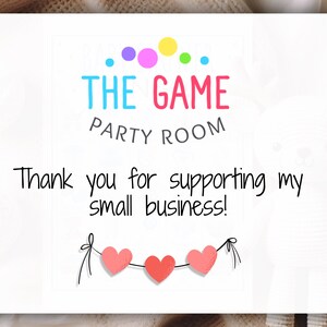 May include: A white card with the words "THE GAME PARTY ROOM" in colourful letters. The text "Thank you for supporting my small business!" is below. Three red hearts are strung across the bottom.