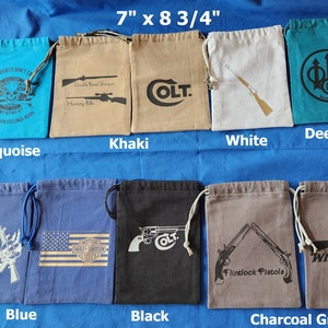 May include: Ten drawstring bags in various colors, each with a different design. The bags are 7 inches by 8 3/4 inches. The designs include a skull, a rifle, a Colt logo, a trident, a Harley Davidson logo, a Winchester logo, and a pair of flintlock pistols.