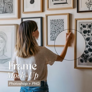 May include: A woman adjusting a framed artwork on a white wall, part of a gallery display. The frames are various sizes and colors, with artwork in black and white. Text on the image reads "Frame Mock-Up Photoshop + PNG."