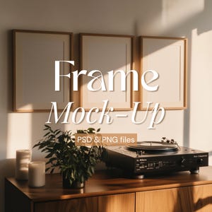 Peut inclure: Trois cadres photo en bois avec des passe-partout blancs sur une table en bois avec un tourne-disque et une plante en pot. Les cadres sont vides et le texte "Frame Mock-Up PSD & PNG files" est sous les cadres.