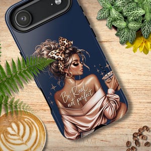Op de afbeelding: Donkerblauwe telefoonhoes met een illustratie van een vrouw met een luipaardprint hoofdband, gouden oorbellen en een roze satijnen top. De tekst "Be Real not perfect" staat op de huid van de vrouw. Ze houdt een drankje met een rietje vast.