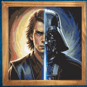 May include: Cross-stitch artwork in a wooden frame, depicting a split image of Anakin Skywalker and Darth Vader from Star Wars. The artwork features a blue lightsaber dividing the two characters, with a background of yellow and blue hues.