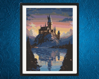 May include: A cross-stitch pattern featuring a large castle perched on a rocky cliff above a calm lake. The scene includes a sunset sky with shades of orange, purple, and blue, snow-capped mountains in the distance, and dark pine trees in the foreground.