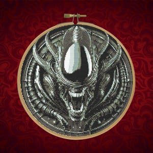 May include: A detailed cross-stitch of the Alien Xenomorph head, featuring a metallic silver and black color scheme. The design is set within a wooden embroidery hoop, showcasing the creature's menacing features against a red patterned background.