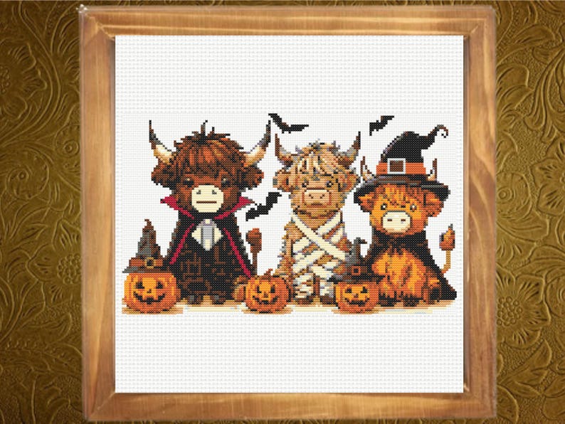 May include: A cross-stitch pattern featuring three Highland cows dressed for Halloween. One cow wears a vampire cape, one is wrapped like a mummy, and one wears a witch hat. Three jack-o'-lanterns sit in front of them, and black bats fly above.