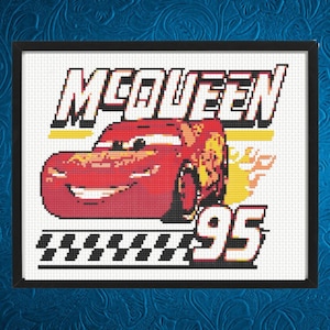 May include: Cross-stitch artwork featuring Lightning McQueen from the movie Cars. The design includes the name "McQueen", the number "95", and a checkered flag. The car is red with yellow and orange flames.