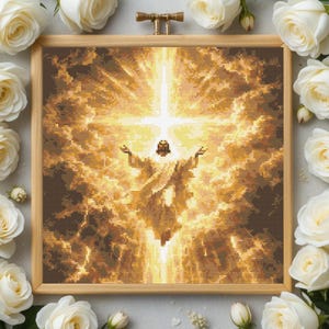 Könnte beinhalten: Ein gerahmtes Kreuzstichbild, das eine religiöse Szene mit einer Figur in hellem, goldenem Licht zeigt. Die Figur hat ausgestreckte Arme, umgeben von einem strahlenden Kreuz und Wolken. Das Kunstwerk ist in hellem Holz gerahmt und von weißen Rosen umgeben.