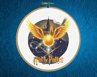 May include: A circular cross-stitch embroidery in a wooden hoop featuring a golden snitch with large wings, a dark castle silhouette, a white owl, and two crossed wands. The text Harry Potter is stitched in yellow at the bottom against a dark blue night sky.