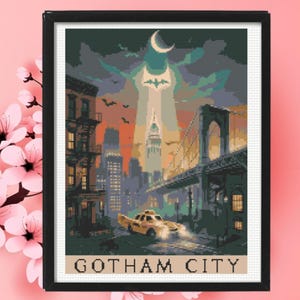 May include: A framed cross-stitch pattern depicting a city skyline at night with a yellow taxi in the foreground, a bridge on the right, a bat signal in the sky, and a crescent moon. The text GOTHAM CITY is printed in black at the bottom of the image.