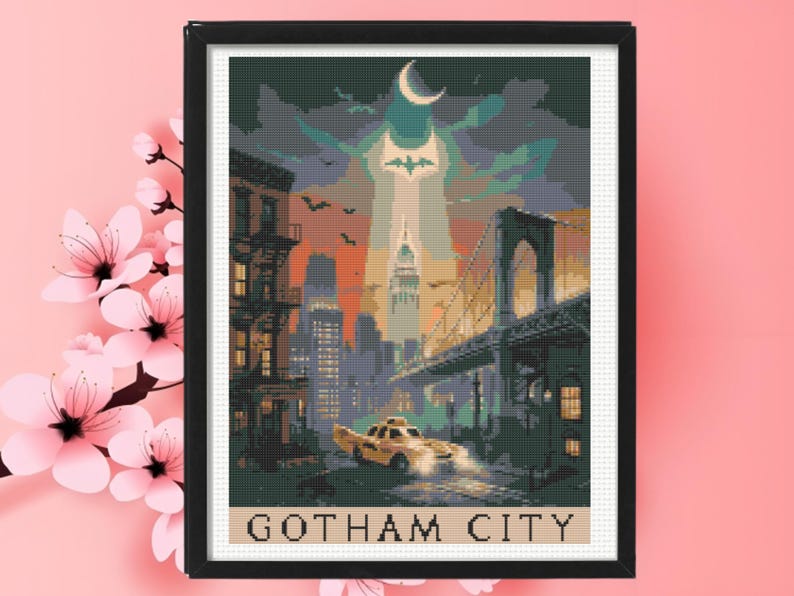 May include: A framed cross-stitch pattern depicting a city skyline at night with a yellow taxi in the foreground, a bridge on the right, a bat signal in the sky, and a crescent moon. The text GOTHAM CITY is printed in black at the bottom of the image.