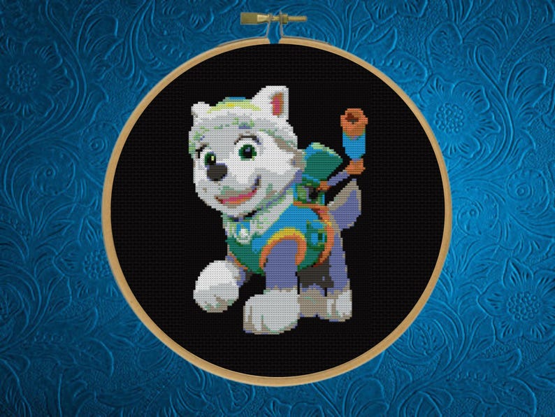 May include: A cross-stitch embroidery piece featuring a white puppy character with green and blue gear, including a backpack and a telescope, set against a solid black background and framed within a circular wooden embroidery hoop.