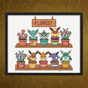 Può includere: Schema di ricamo a punto croce con personaggi Pokémon in un negozio di fiori. Il cartello sopra il negozio recita "FLORIST".
