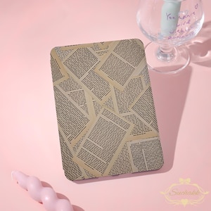 May include: A rectangular e-reader case featuring a collage pattern of overlapping vintage book pages with black printed text on a tan background. The case has rounded corners and a flat surface, displaying a repeating literary design.