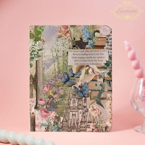 May include: A decorative journal with a collage design featuring butterflies, flowers, and a castle. The journal has a vintage aesthetic with text that reads "the more I seek Him the more I notice flowers landing next to my feet birds singing outside my window all love letters from the God who knows no coincidence."