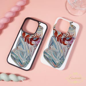 May include: Two phone cases with a Diet Coke can design. The cases feature a crushed can with the words "Diet" and "Sugar Calories" visible. One case has a black border, the other a white border. The cases are on a pink surface.