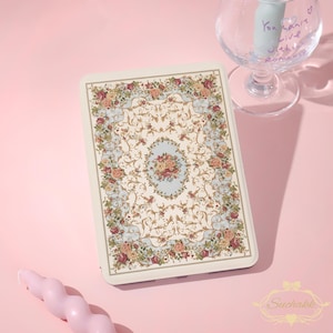 May include: A rectangular tablet case featuring a cream-colored background with an intricate floral pattern of red and pink roses, gold scrolling vines, and light blue accents. The design is symmetrical with a central oval floral motif.