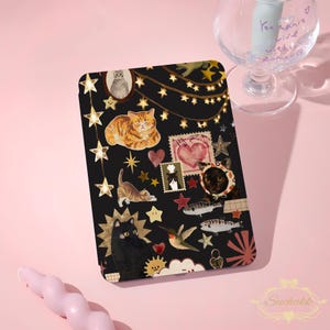 Op de afbeelding: Zwarte rechthoekige hoes met een collage van kattenillustraties, sterren, harten en postzegels. De hoes heeft verschillende kattenrassen in verschillende poses, samen met decoratieve elementen zoals sterren en een lichtslinger. De hoes heeft een glanzende afwerking.