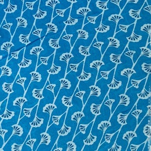 K&ouml;nnte beinhalten: Ein leuchtend blauer Stoff mit einem sich wiederholenden Muster aus wei&szlig;en, stilisierten Ginkgo-Blattmotiven, die in diagonalen Linien angeordnet sind. Das Design besteht aus zarten, d&uuml;nnen Stielen mit f&auml;cherf&ouml;rmigen Bl&auml;ttern und einer Textur.