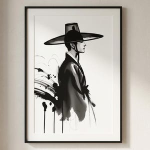Può includere: Una stampa artistica incorniciata raffigurante un'illustrazione a inchiostro bianco e nero di una persona di profilo che indossa un cappello a tesa larga e una veste tradizionale. L'opera utilizza pennellate espressive e schizzi di colore.