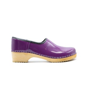 May include: Purple leather clogs with a wooden sole. The clogs have a black trim around the top and a white stitch around the sole.