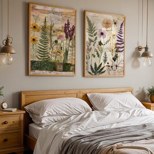 Two framed botanical prints displayed on the wall above a wooden bed with white linens.
