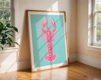 May include: A framed art print featuring a pink lobster illustration against a teal background. The lobster is detailed with a gradient effect, and the frame is a warm wood tone. The artwork leans against a wall near a window, suggesting a coastal or nautical theme.