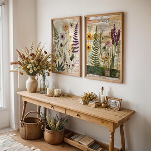 Two framed botanical prints hanging side by side on a white wall above a rustic wooden console table.