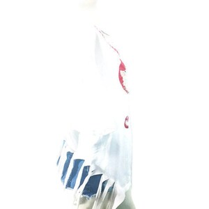 Puede incluir: Camiseta blanca con bordes deshilachados y un estampado gr&aacute;fico rojo y azul. La camiseta est&aacute; en un maniqu&iacute; blanco.