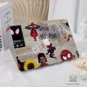 May include: A laptop case featuring Spider-Man graphics and the phrase "WHERE IS MY MIND?" in a collage style. The design includes images of Spider-Man, a sunflower, and a red high-top sneaker. The case also has a phone with a Spider-Man theme.