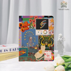 Pode incluir: Um caderno colorido com um design de colagem com uma roda gigante, flores e um gato. As palavras "Chill Out" são exibidas de forma proeminente. O caderno é uma mistura vibrante de cores e padrões.