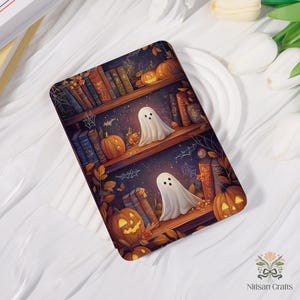 May include: A rectangular Halloween design depicting a bookshelf with pumpkins, ghosts, and books. The design uses a dark colour palette with orange, brown, and purple hues. The ghosts are white with black dot eyes.