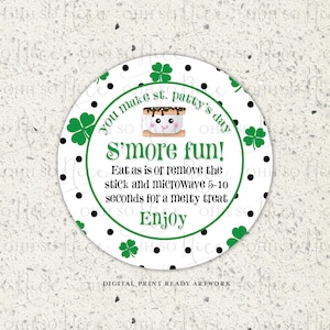 Op de afbeelding: Een ronde witte sticker met zwarte stippen en groene klavertjes. De sticker zegt "You make st. patty's day SO S'more fun! Eat as is or remove the stick and microwave 5-10 seconds for a melty treat Enjoy".
