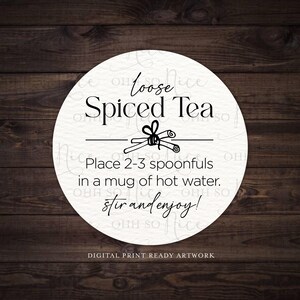 Op de afbeelding: Wit rond label met zwarte tekst die "Loose Spiced Tea" luidt met een kaneelstokje-illustratie. De instructies luiden: "Doe 2-3 eetlepels in een mok heet water. Roer en geniet!"