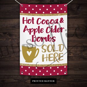 May include: A white banner with red polka dots and gold glitter accents. The text reads "Hot Cocoa & Apple Cider Bombs SOLD HERE". A gold mug with a heart and marshmallows is pictured. The banner reads "PRINTED BANNER" at the bottom.
