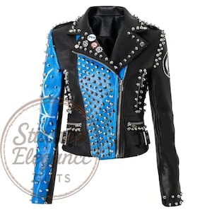 Puede incluir: Chaqueta de cuero negra con detalles azules, adornada con tachuelas y remaches plateados. La chaqueta tiene cierre de cremallera, múltiples bolsillos y alfileres decorativos. Las mangas y los paneles frontales están adornados con tachuelas, creando una estética audaz y vanguardista.