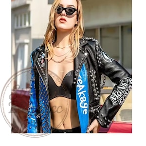 May include: Black leather jacket with silver studs and blue accents. The jacket features the text "eAkage" and "Mons Sou" in white. The jacket has a classic biker style with a modern twist.